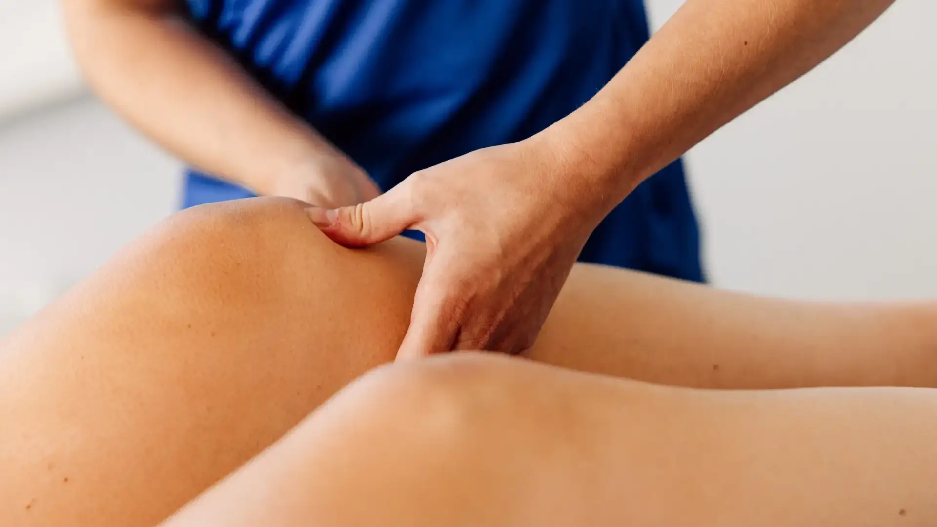 Nahaufnahme einer physiotherapeutischen Triggerpunktbehandlung am Oberschenkel.