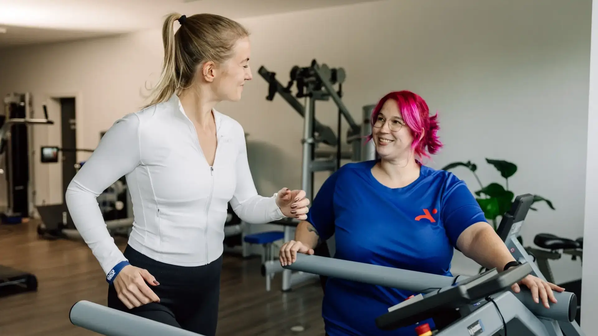 Patientin trainiert auf dem Laufband unter Aufsicht einer Physiotherapeutin.